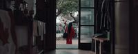 a woman in a red dress walking into a hallway