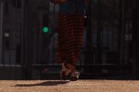 a woman walking down a street holding an umbrella