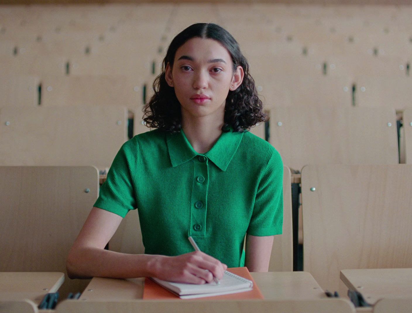 a woman sitting at a desk with a book in front of her