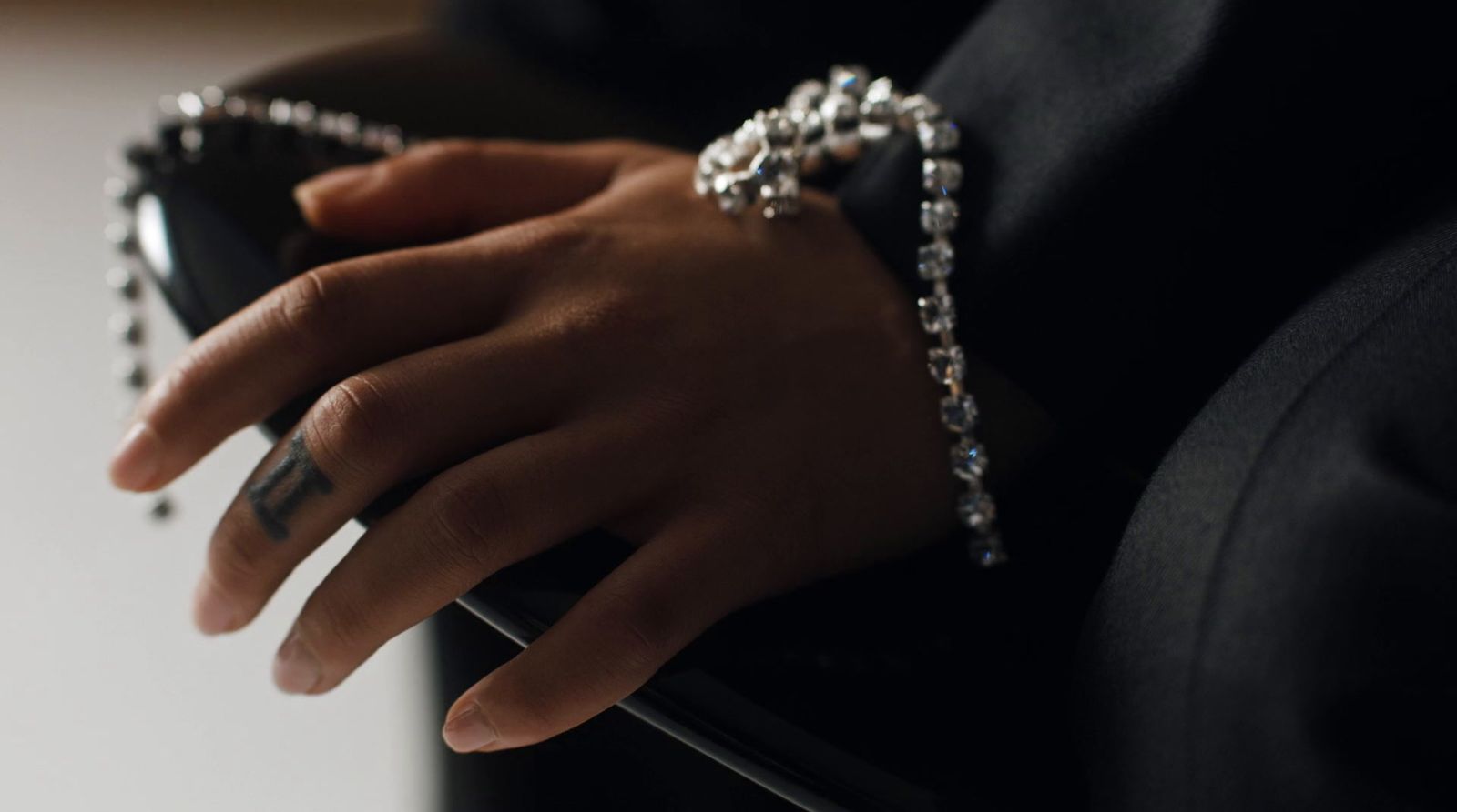 a close up of a person's hand holding a purse