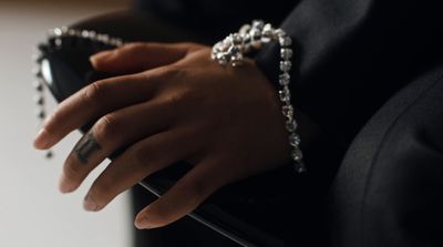 a close up of a person's hand holding a purse