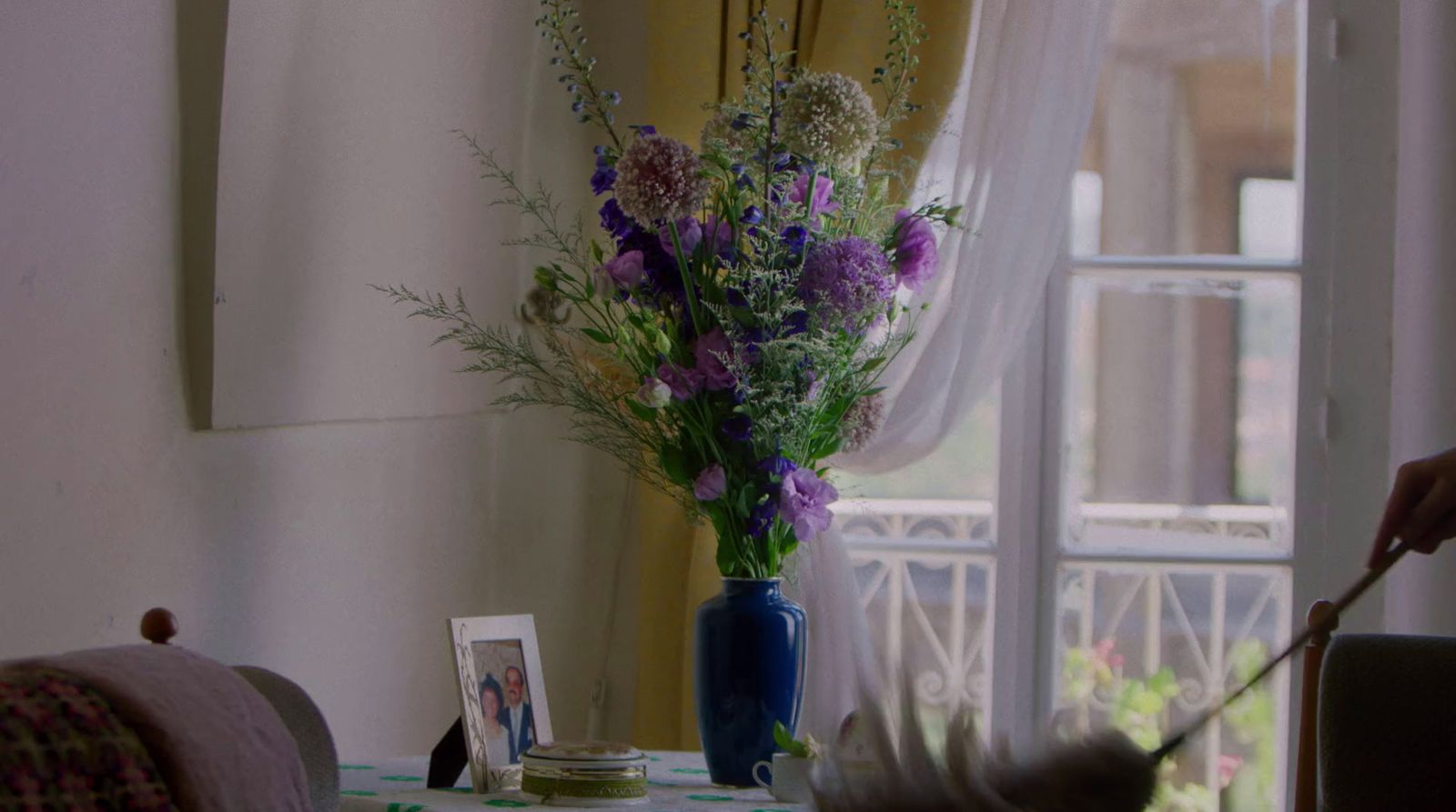 a vase filled with purple flowers sitting on top of a table