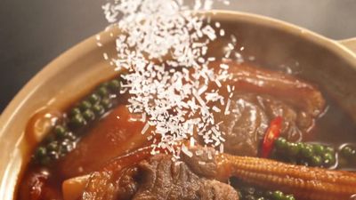 a close up of a bowl of food with rice sprinkled on top