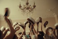 a group of people holding up hats in the air