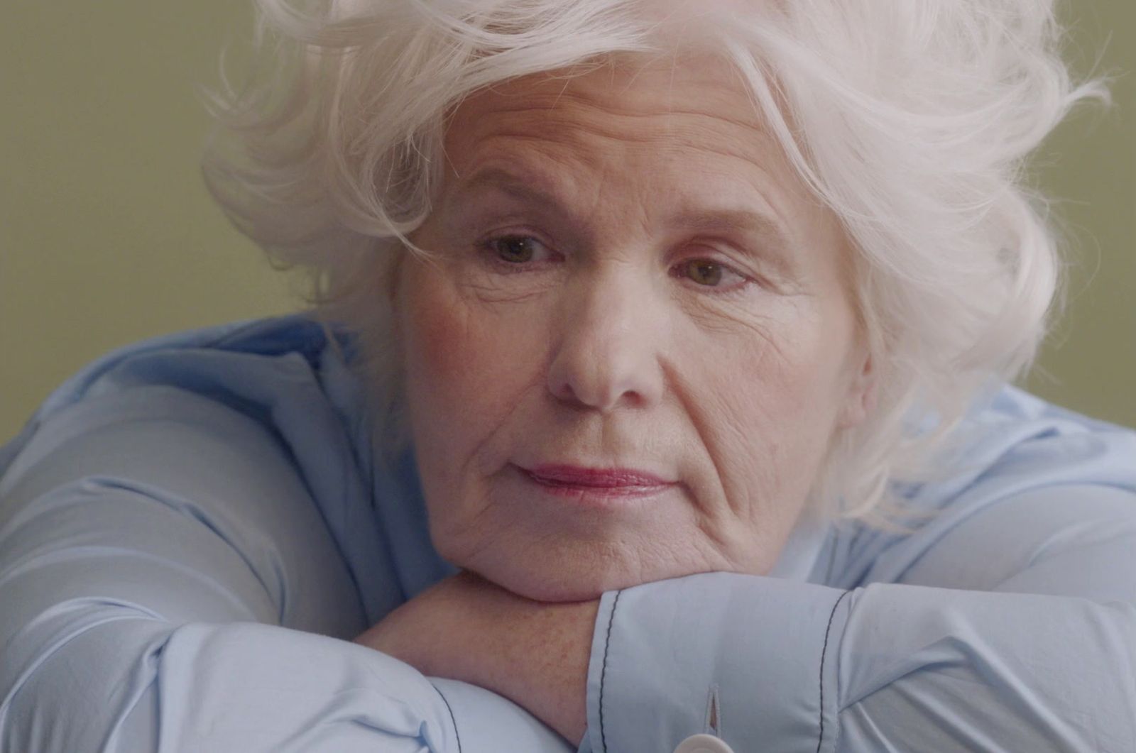 a woman with white hair and a blue shirt