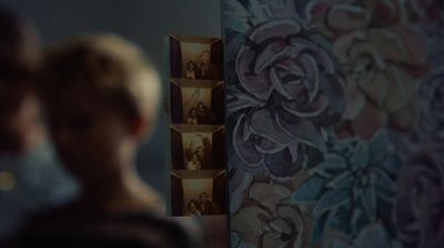 a man and a woman standing in front of a wall with pictures on it