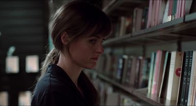 a woman standing in front of a book shelf