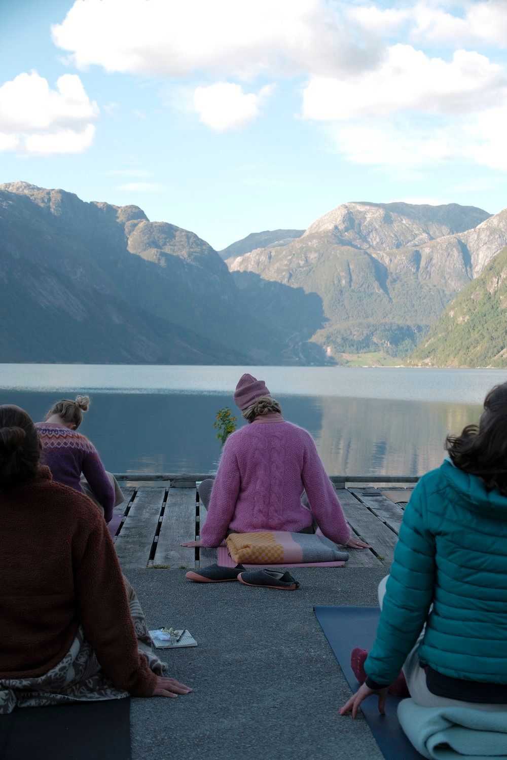 a group of people sitting on top of a wooden dock