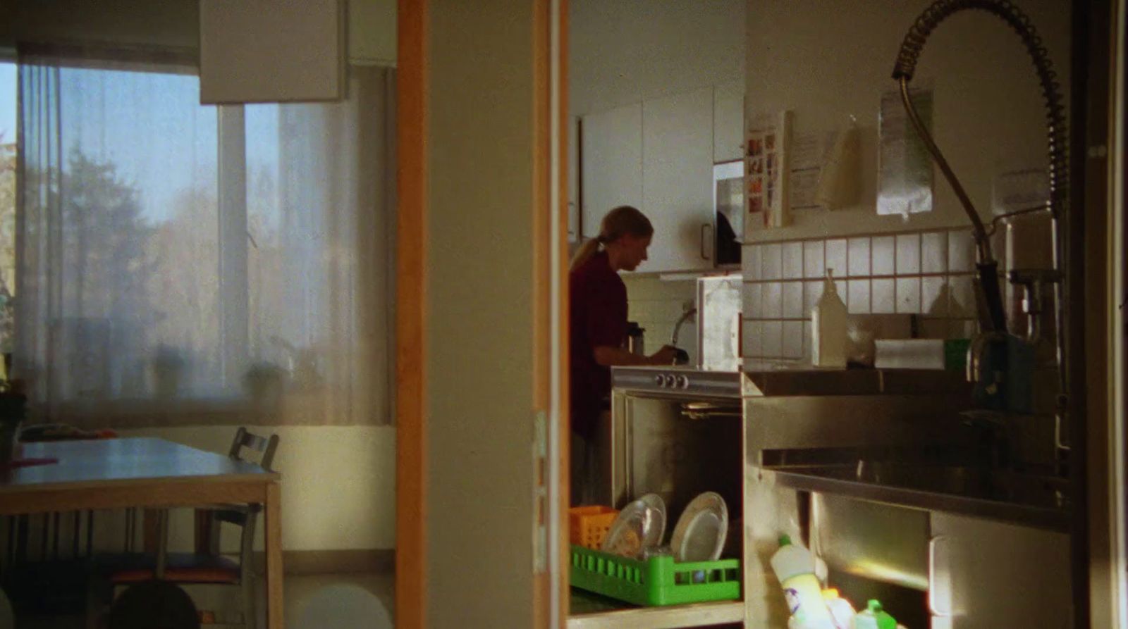 a man standing in a kitchen next to a sink