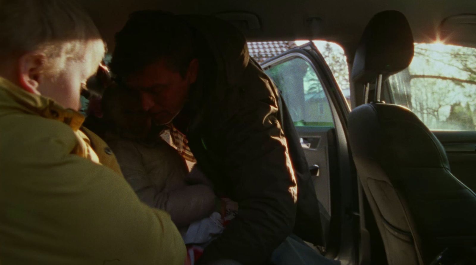 a man holding a baby in a car seat