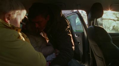 a man holding a baby in a car seat