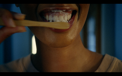 a woman brushing her teeth with a toothbrush