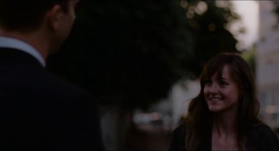 a woman standing next to a man in a suit