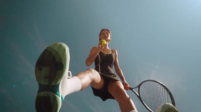 a woman holding a tennis ball and a tennis racquet