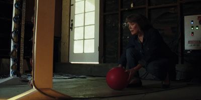 a woman is playing with a red ball