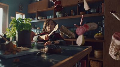 a little girl sitting at a counter in a kitchen