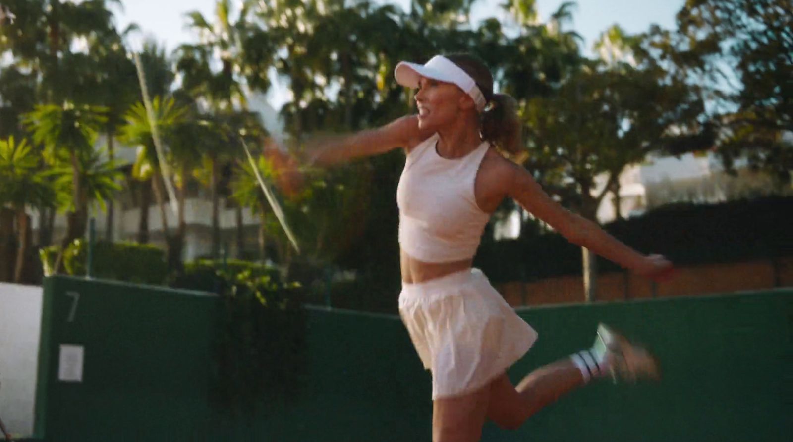 a woman in a white dress is playing tennis