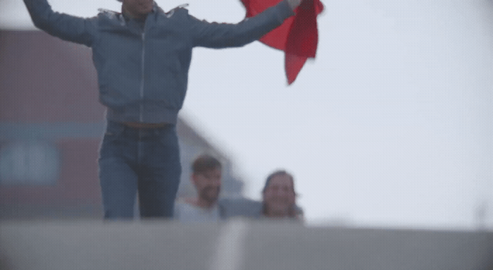 a man holding a red kite in the air