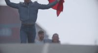 a man holding a red kite in the air