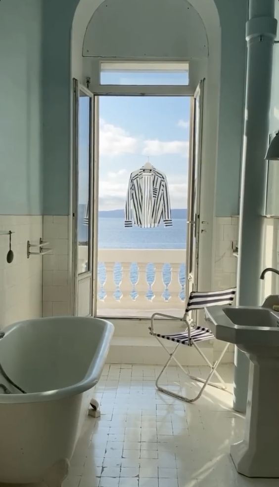 a bathroom with a tub, sink and a large window