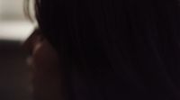 a close up of a person's hair with a cell phone in the background