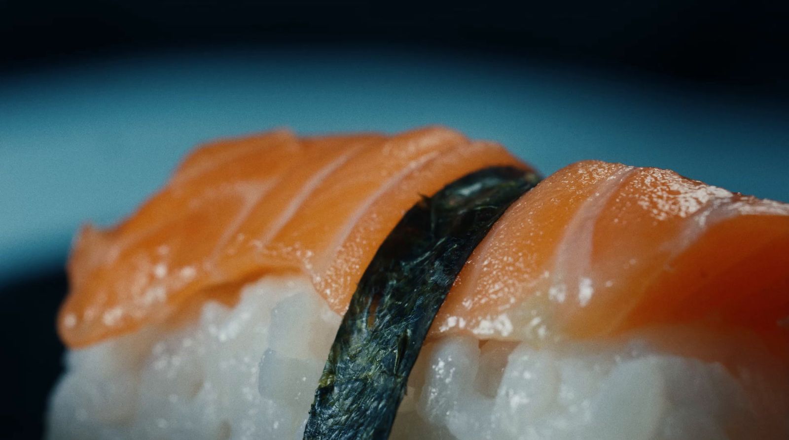 a close up of sushi on a blue plate