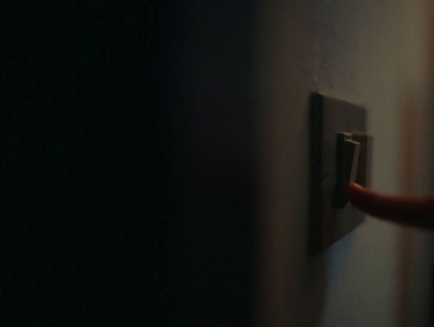 a person turning on a light switch in a dark room