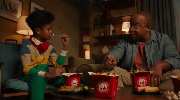 a man and a woman sitting on a couch eating