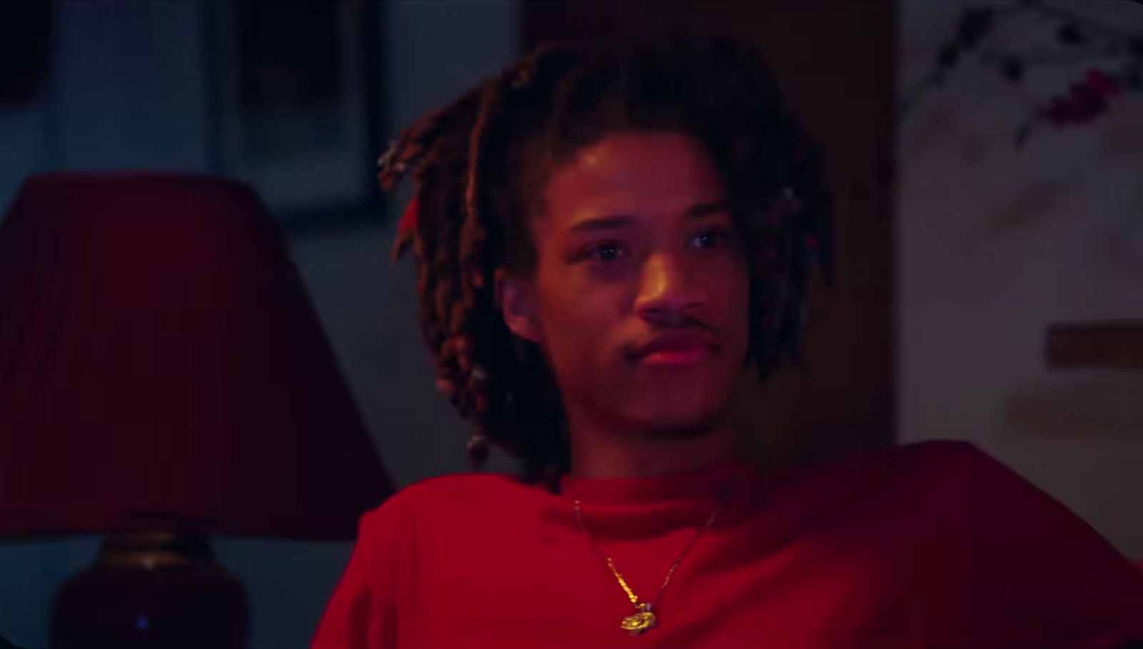 a man with dreadlocks wearing a red shirt