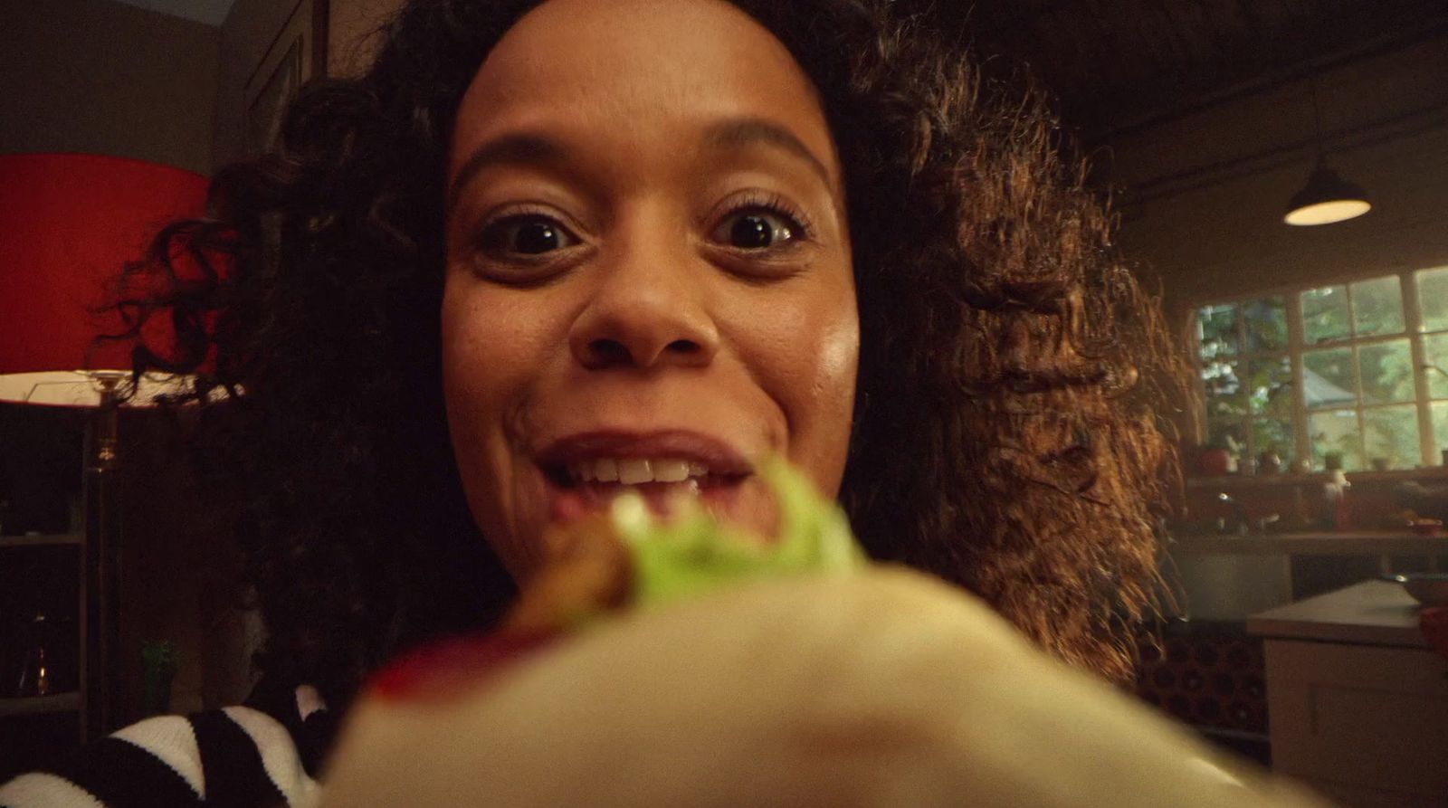 a woman holding a piece of food up to her mouth