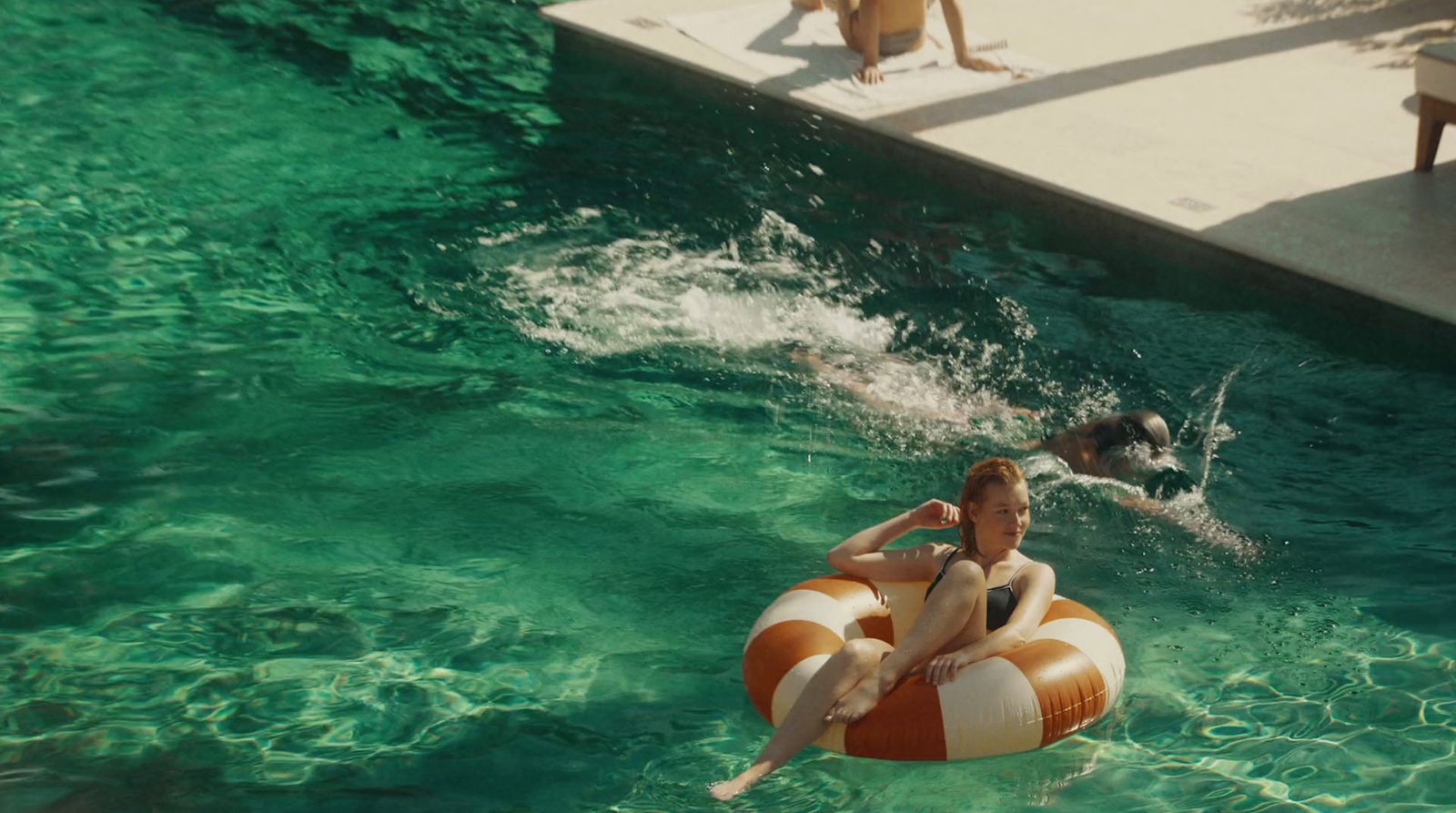 a woman floating on an inflatable raft in a pool