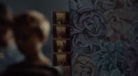 a woman standing in front of a wall with pictures on it