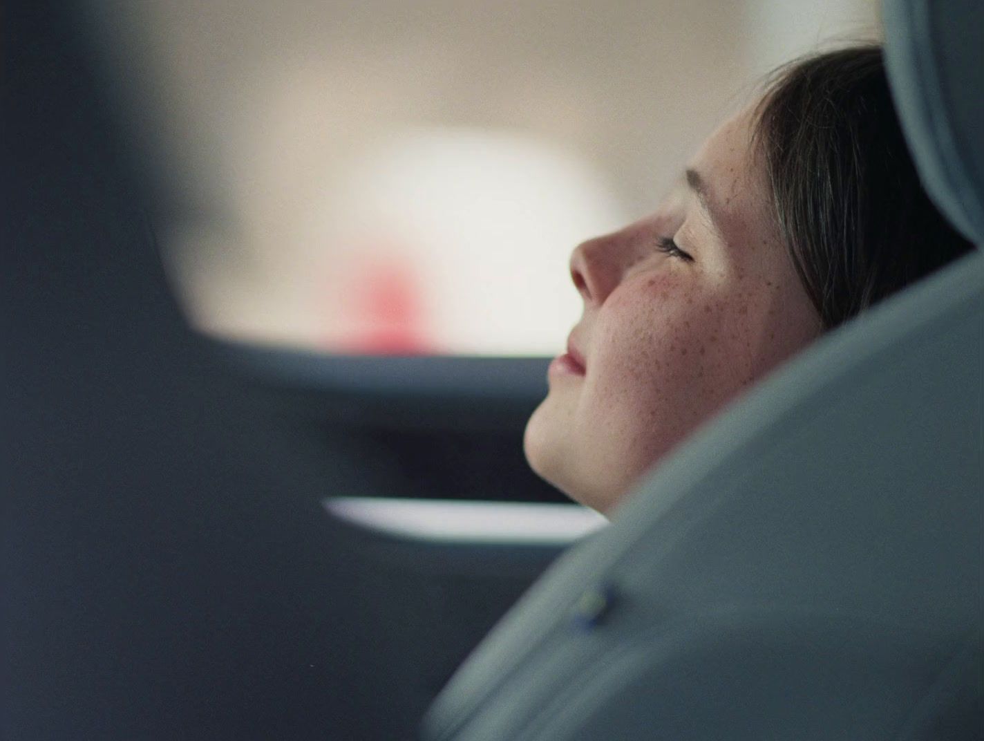 a woman sitting in a car looking out the window