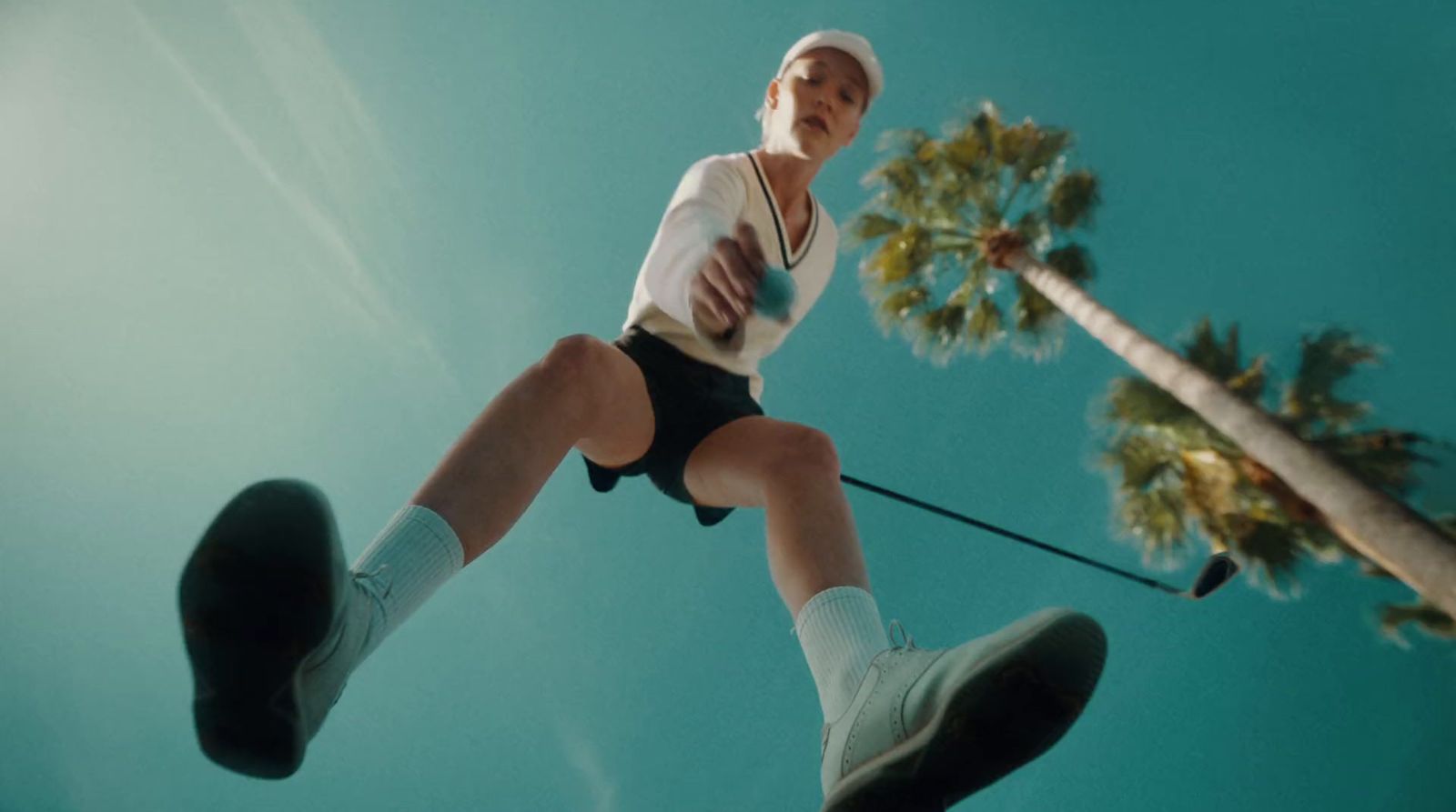 a man in a white shirt and black shorts standing on a rope