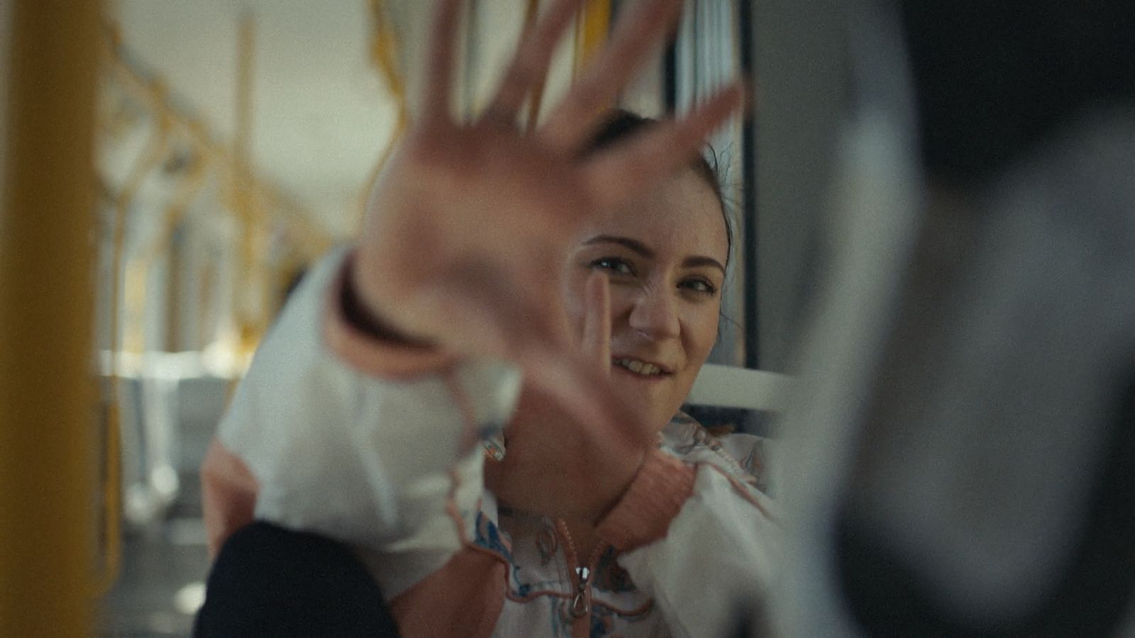 a woman making a hand gesture on a bus