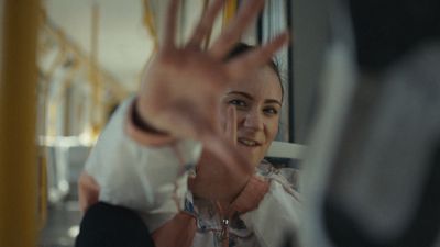 a woman making a hand gesture on a bus