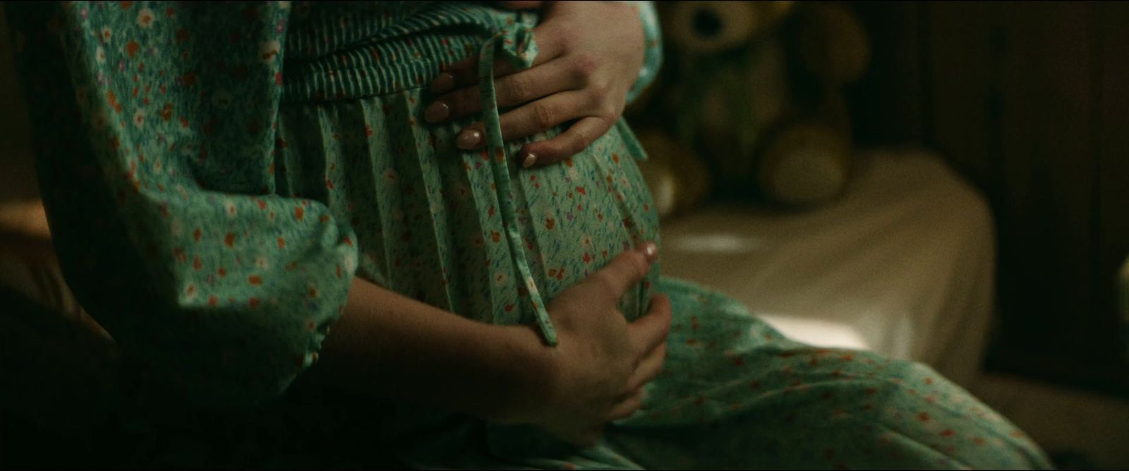 a pregnant woman holding a knife in her belly