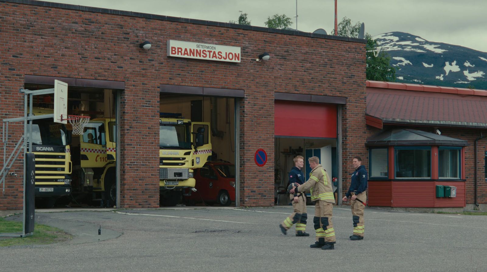 a group of men standing outside of a fire station