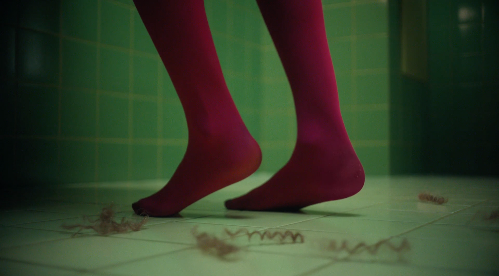 a pair of legs in red socks standing on a tiled floor