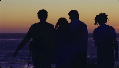 a group of people standing next to each other near the ocean