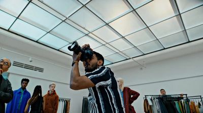 a man taking a picture of a group of mannequins