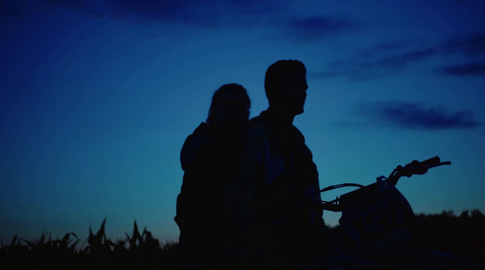 a man and a woman standing next to a bike