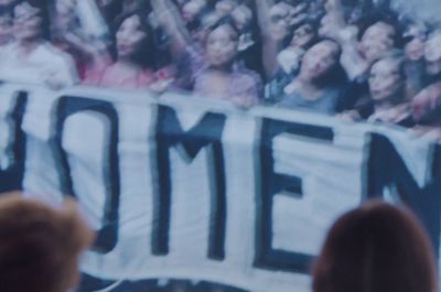 a crowd of people standing around a large banner