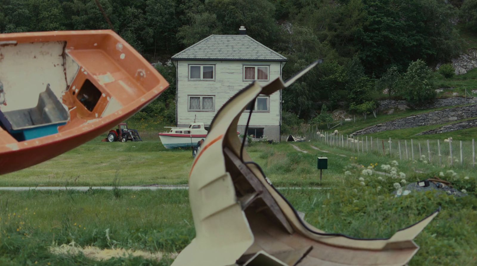 a boat sitting on top of a lush green field