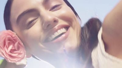 a close up of a person holding a flower