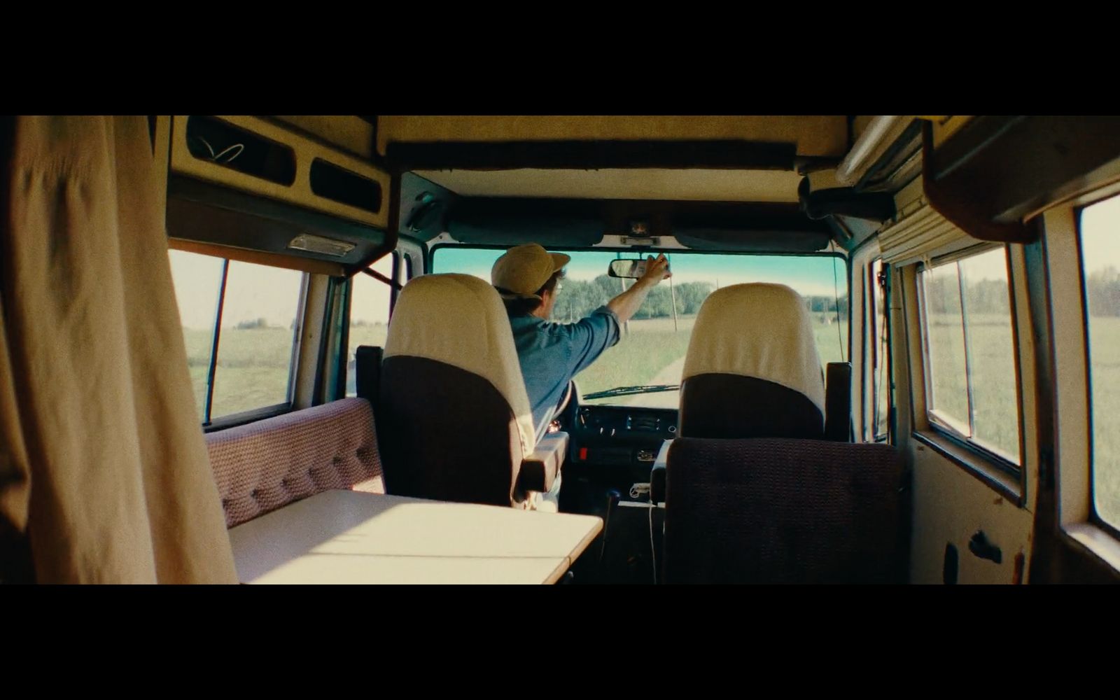 a man sitting in the back of a bus next to a table