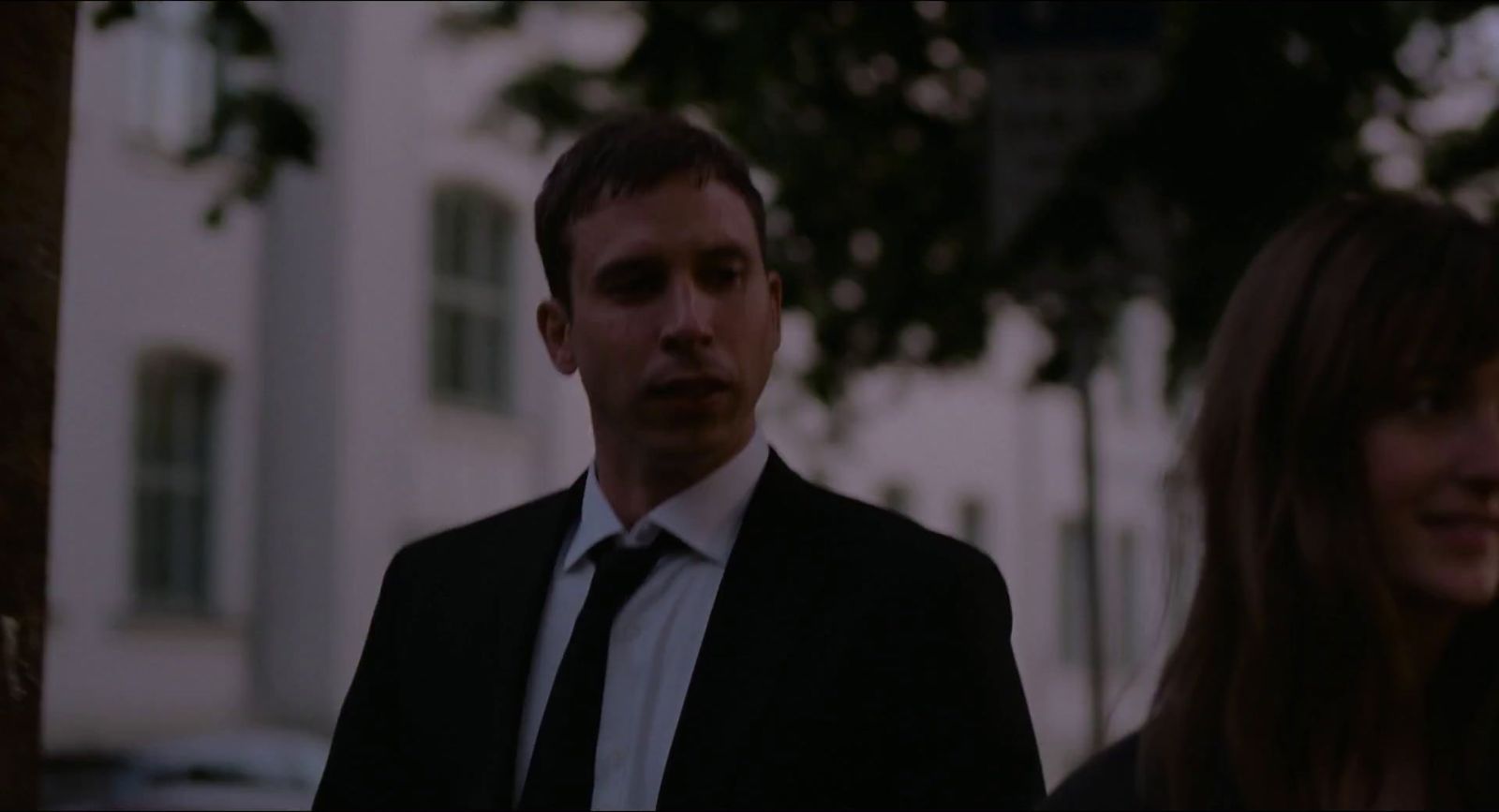 a man in a suit and tie standing next to a woman