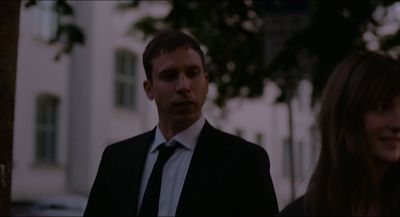 a man in a suit and tie standing next to a woman