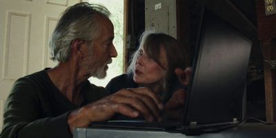 a man and a woman looking at a laptop screen