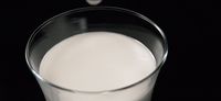 a glass of milk on a black background